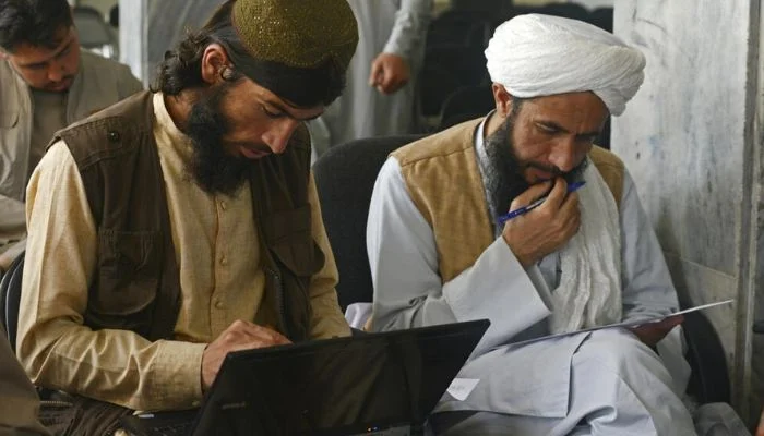 As hundreds of students return to school, Taliban soldiers trade their weapons for books